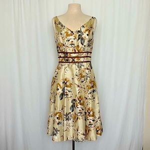 Sleeveless v-neck dress with vintage floral pattern and ribbon trim.
